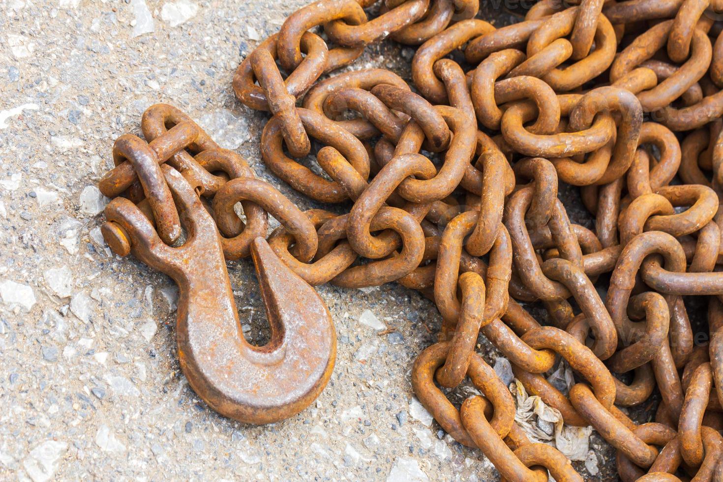 Rusty hook and chain on floor photo