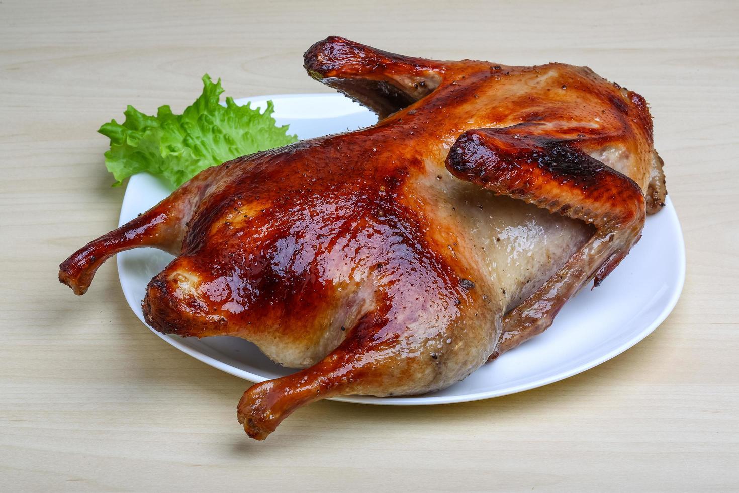 Roasted duck on the plate and wooden background photo