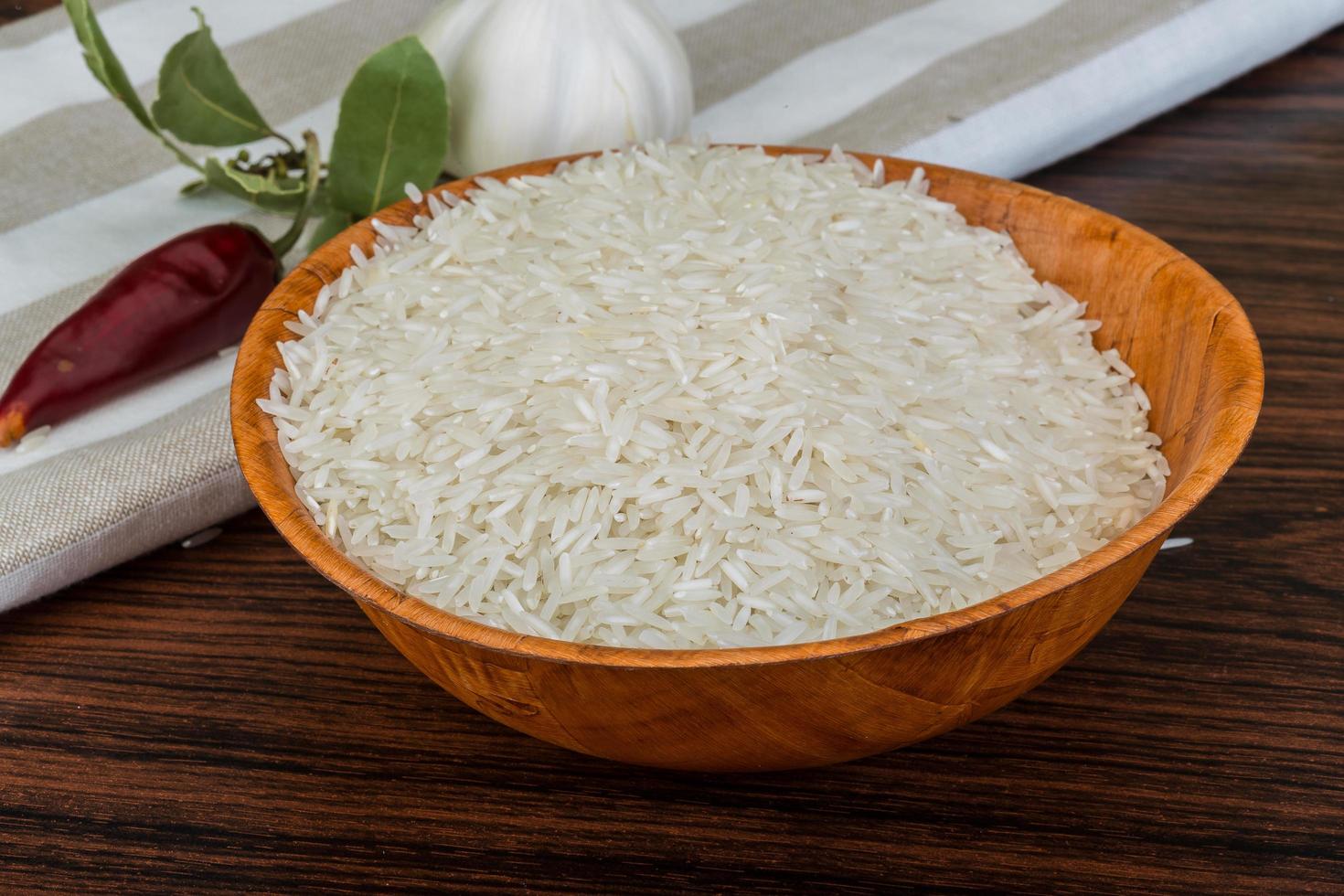 Basmati rice in a bowl on wooden background photo