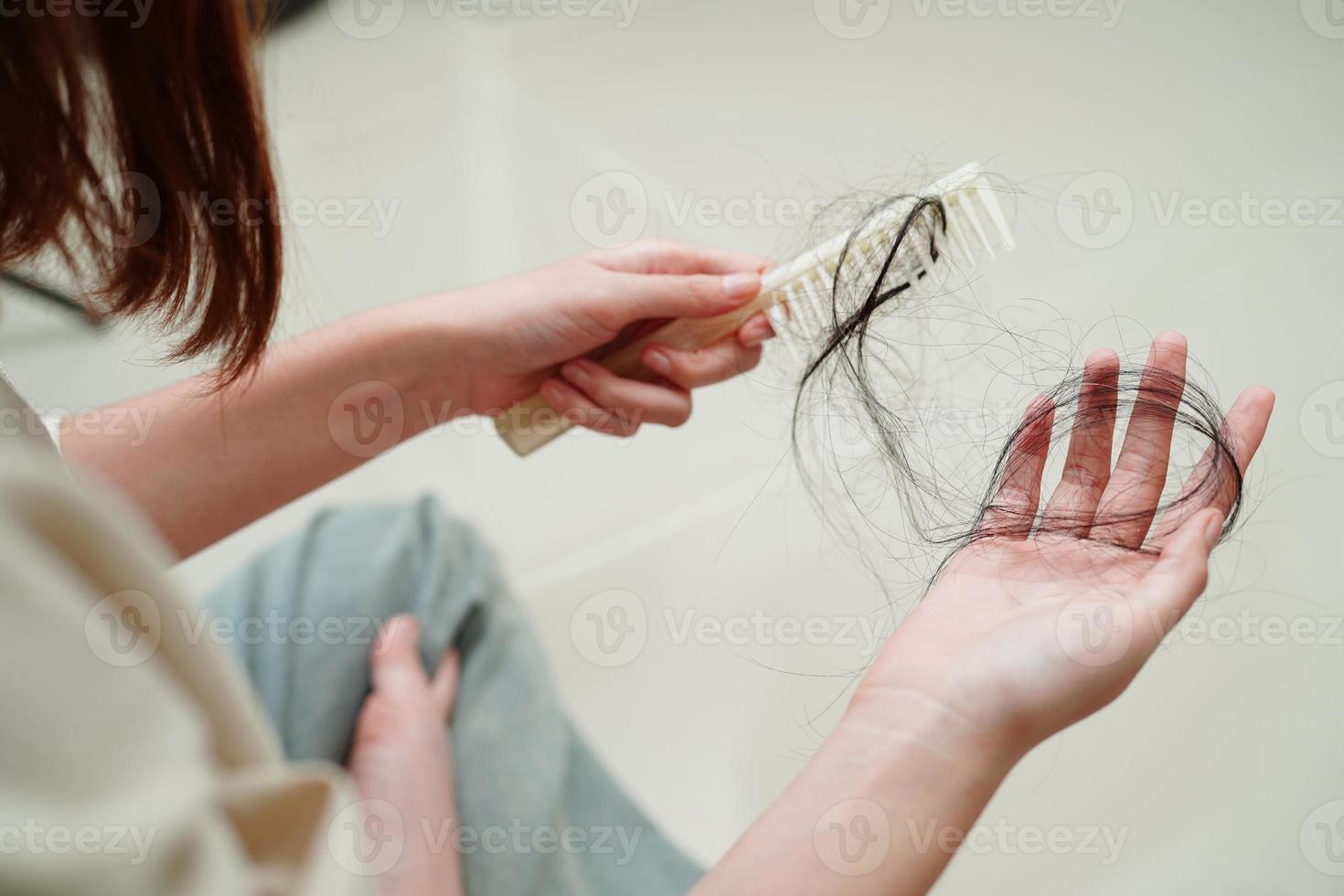 Asian woman have problem with long hair loss attach to comb brush. photo