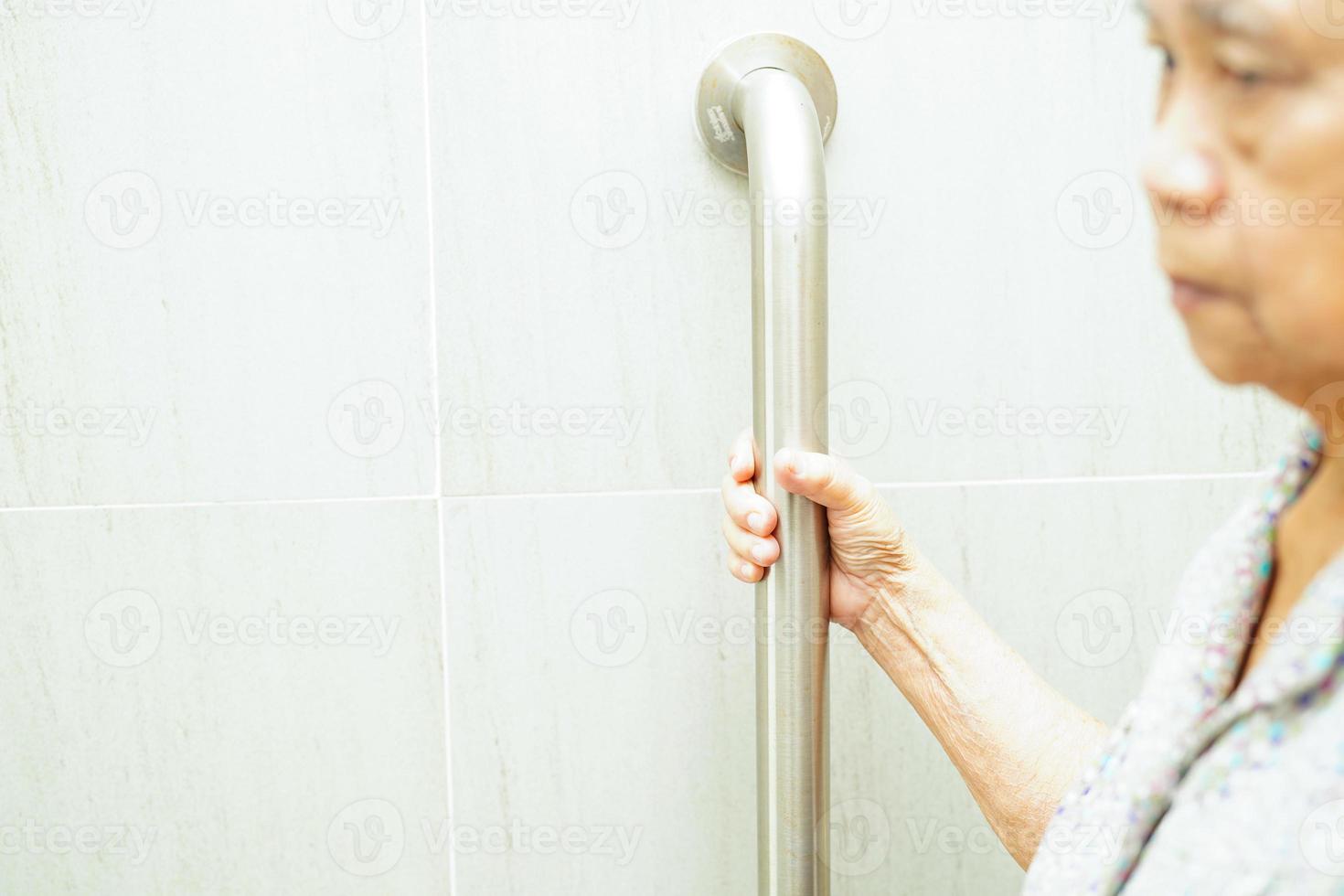 Asian elderly old woman patient use support rail on ramp, handrail safety grab bar, security in nursing hospital. photo