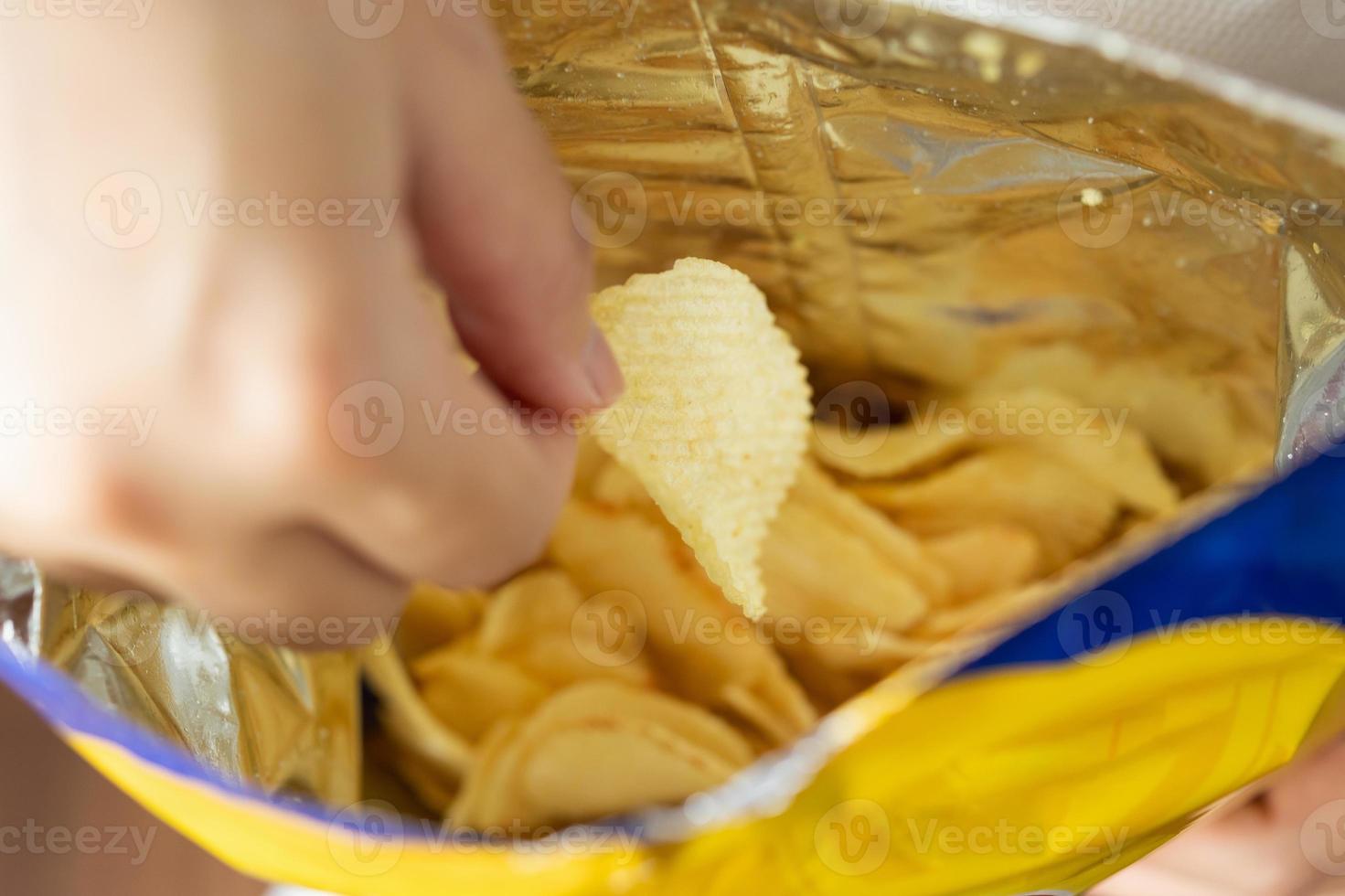 Hand hold potato chips with snack bag photo