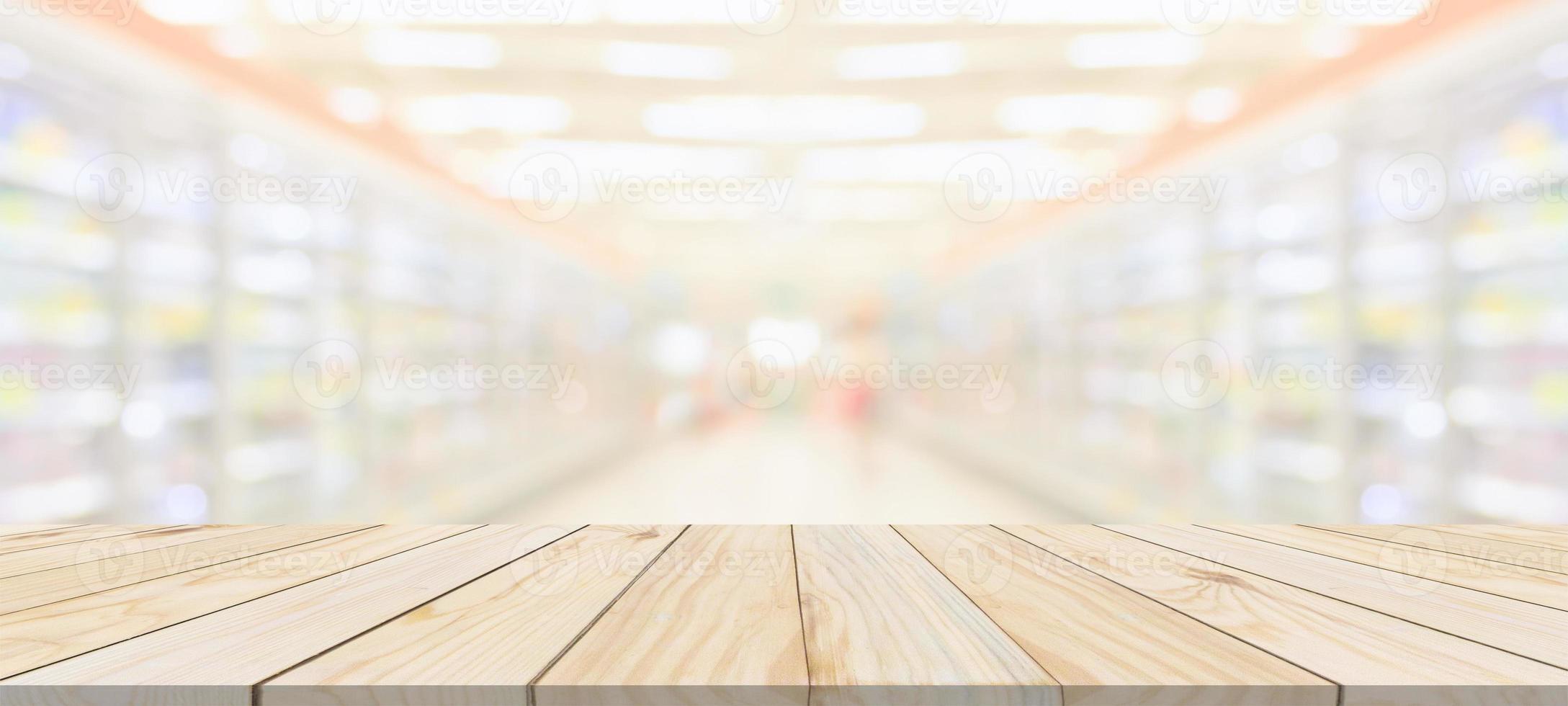 wood table top with supermarket aisle with refrigerators blurred background photo