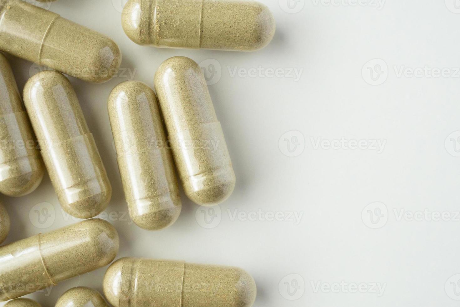 Herbal medicine capsules on white background photo