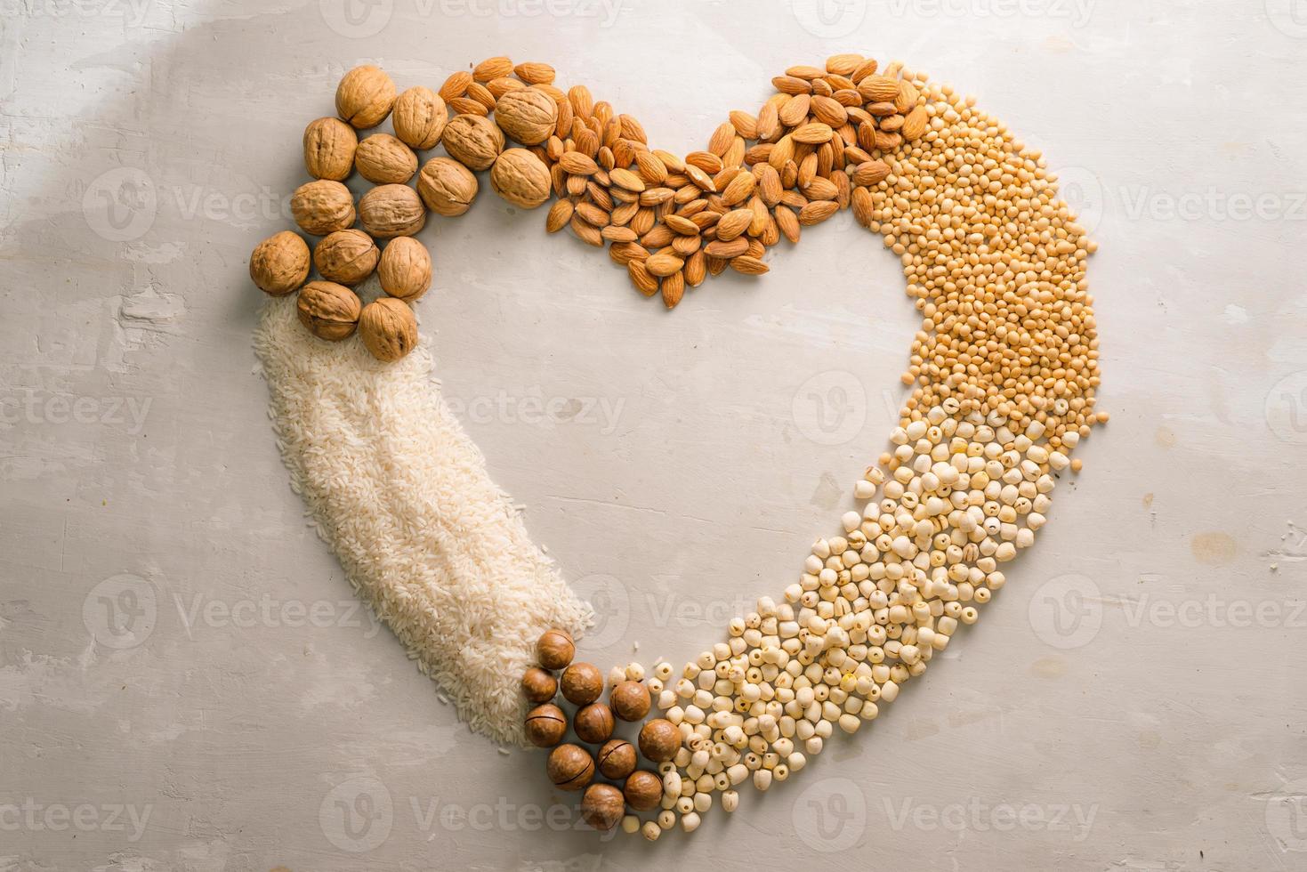 Heart shape of nuts Macadamia, almond, soy, rice, lotus. Top view. photo