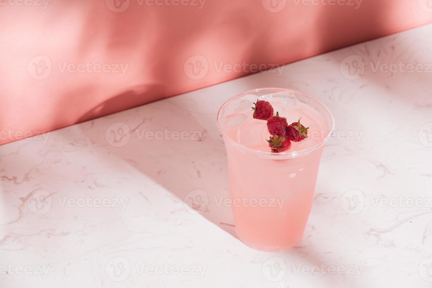 Summer juice with fresh raspberries in a glass on a light background photo