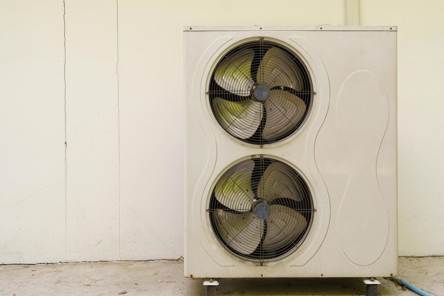 The old air conditioner coil is installed on the floor behind the wall of the house. photo