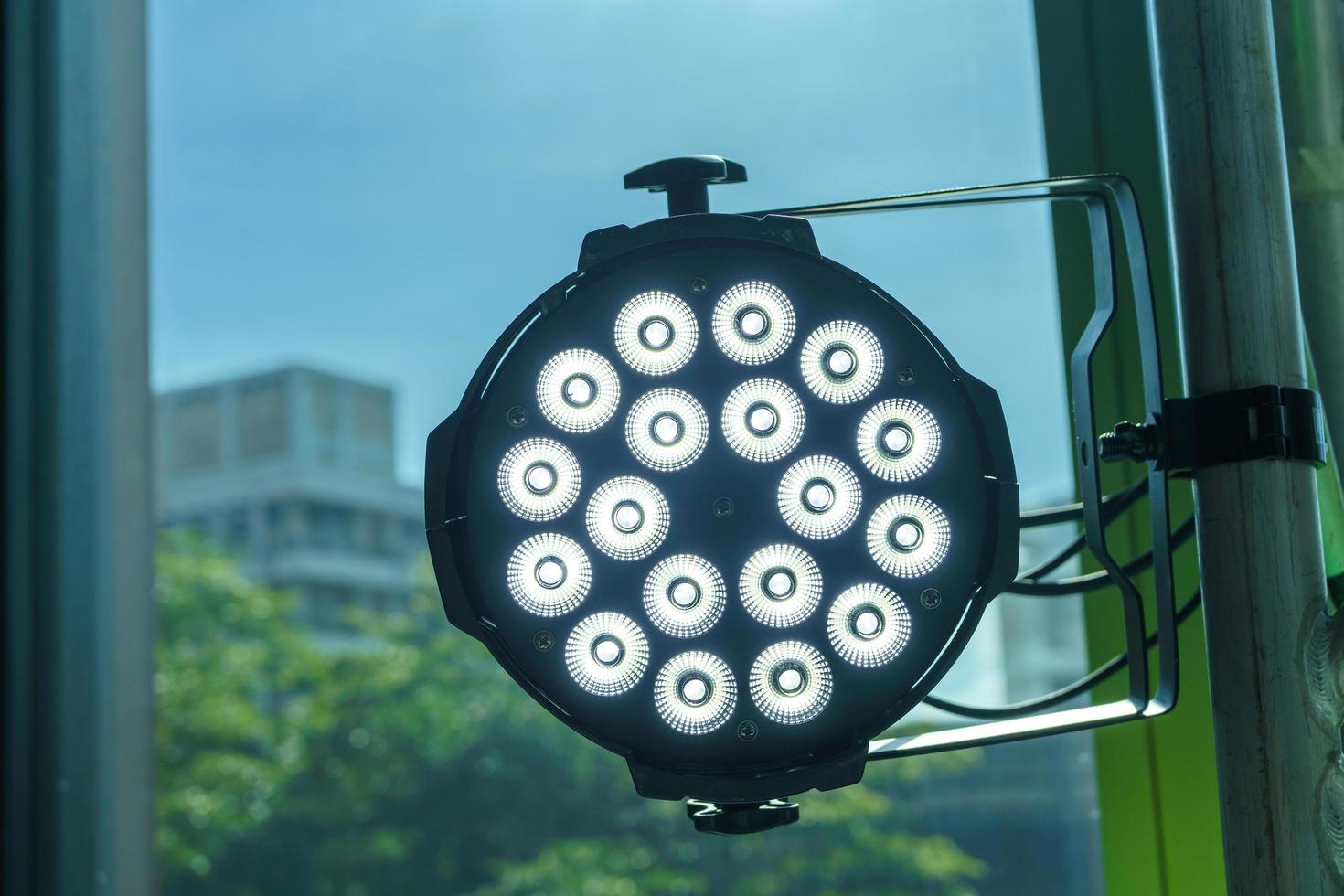 LED lights illuminate a black iron lantern mounted on an aluminum stage structure. photo