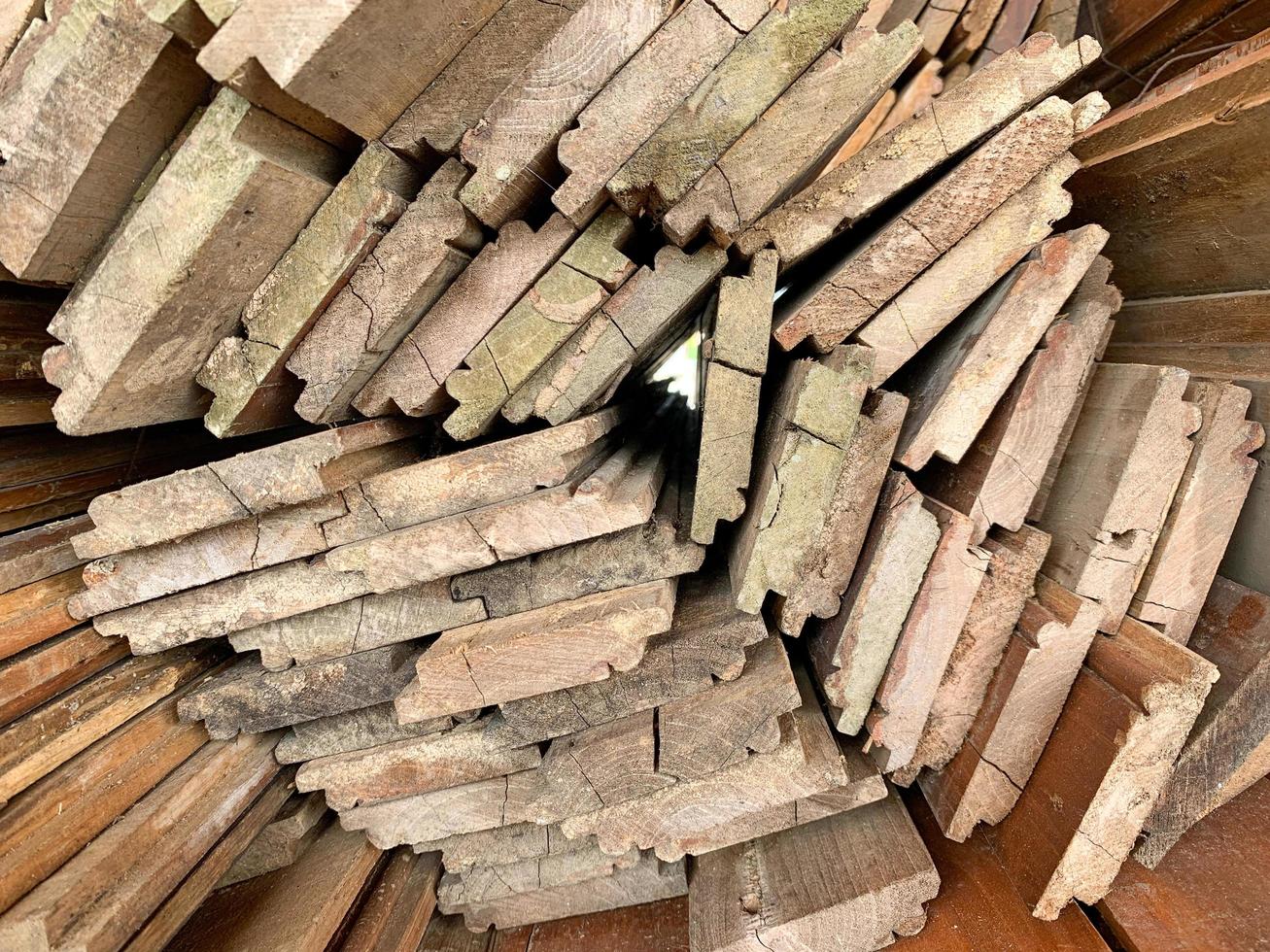 fondo abstracto de madera apilada irregularmente, viejas tablas de madera preparándose para la construcción de la casa, patrón en el borde de varias piezas de madera.foto móvil foto