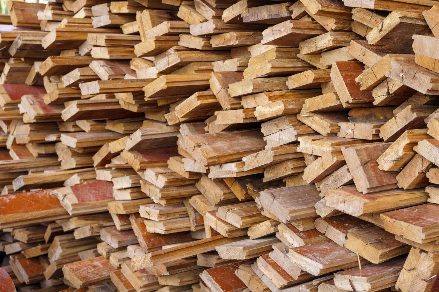 fondo abstracto de madera irregularmente apilada, viejas tablas de madera preparándose para la construcción de la casa, patrón en el borde de varias piezas de madera foto