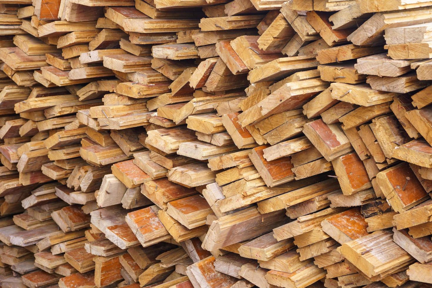 fondo abstracto de madera irregularmente apilada, viejas tablas de madera preparándose para la construcción de la casa, patrón en el borde de varias piezas de madera foto