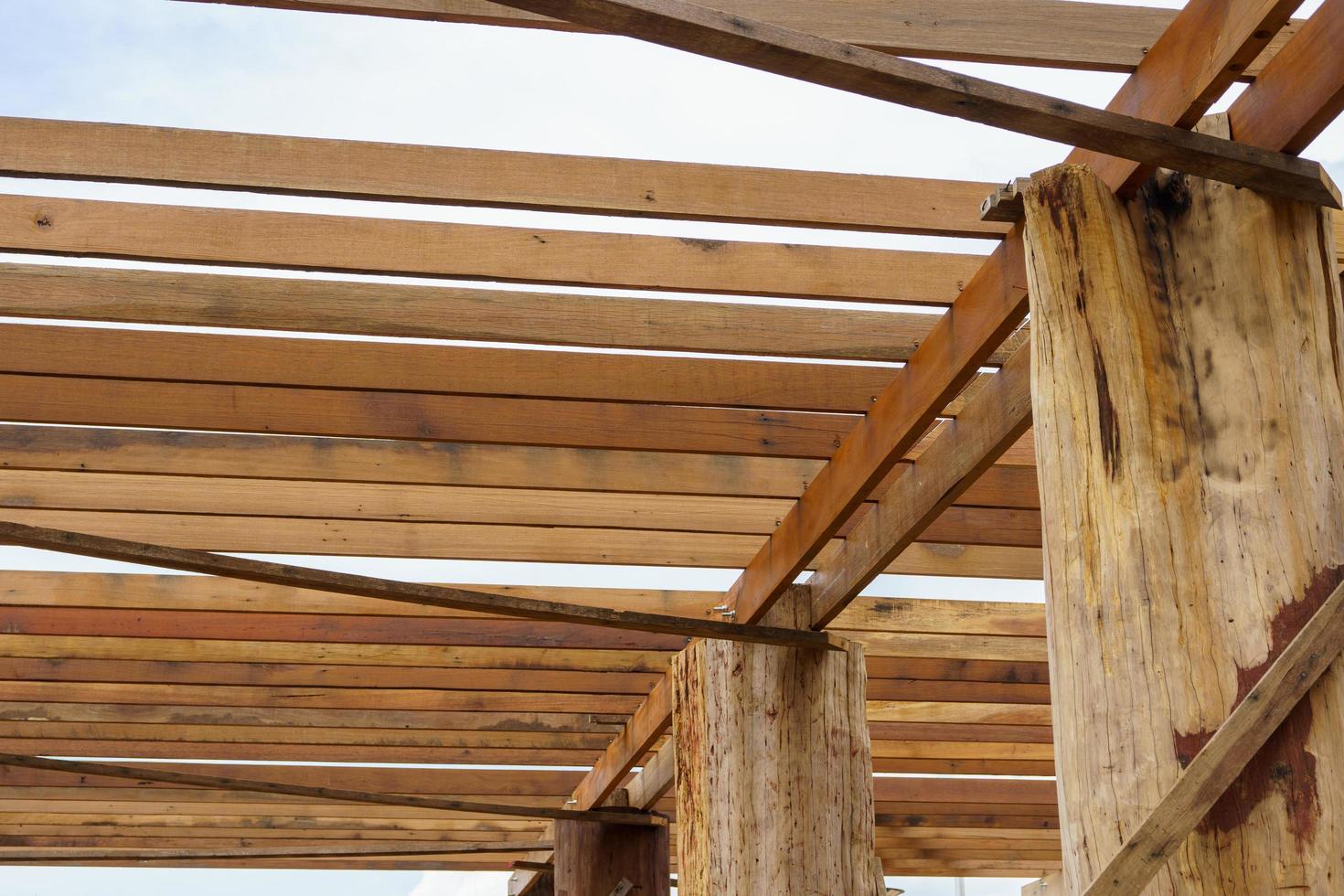 A wooden frame structure with massive supporting pillars prepares the construction of a two-story house. photo