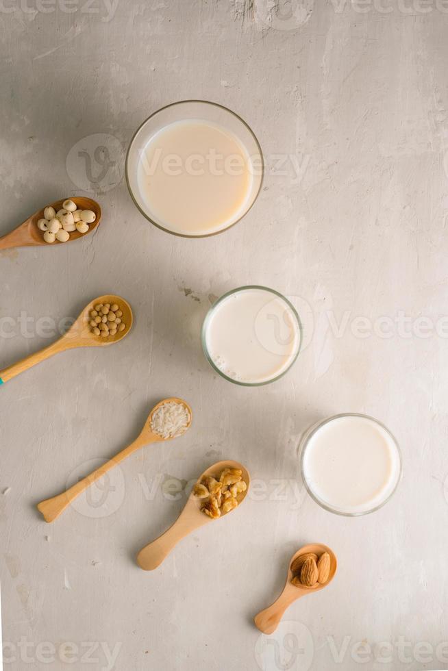 Glasses of milk with nuts Macadamia, almond, soy, rice, lotus. Top view. photo