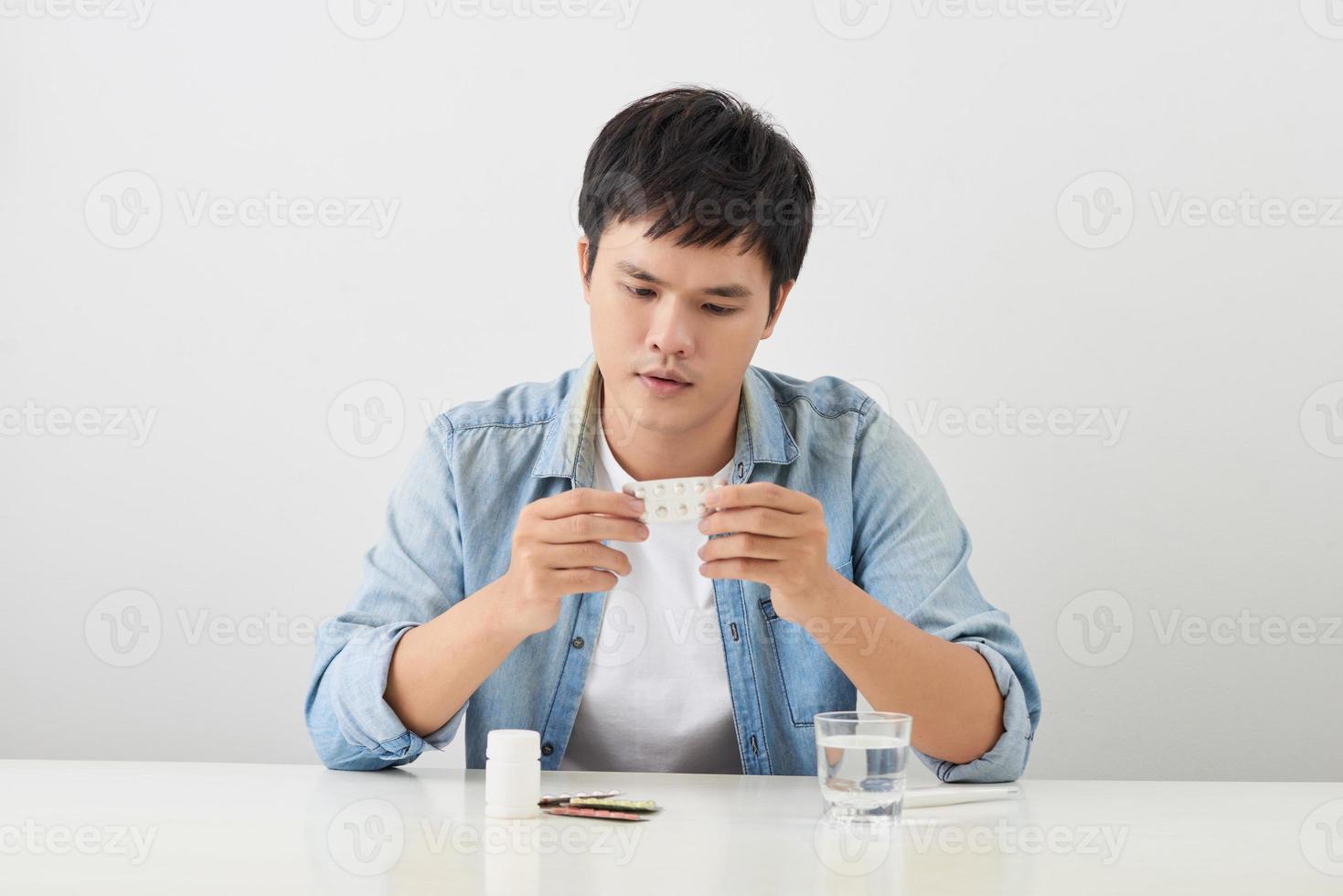 man taking pill out from blister pack at home photo