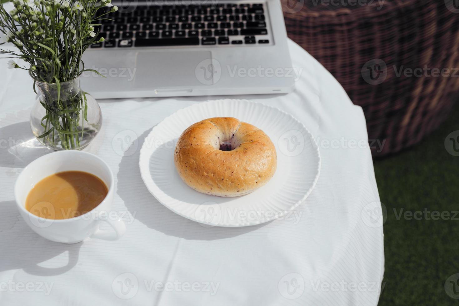 Laptop, bread and cafe in coffee shop photo