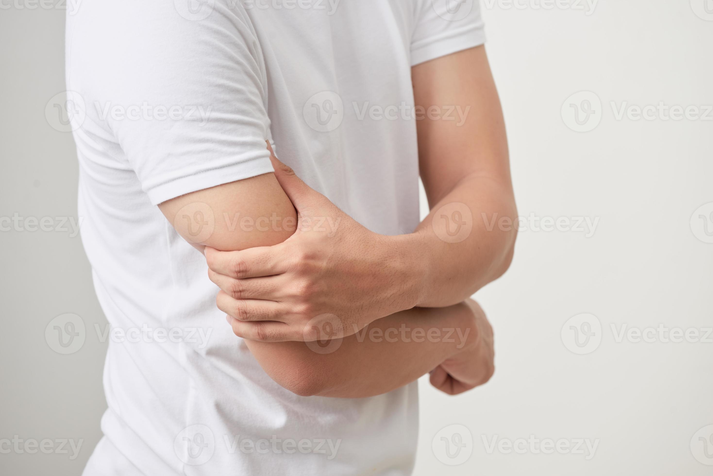 A man an expression of severe pain in arm, muscle tendon or elbow