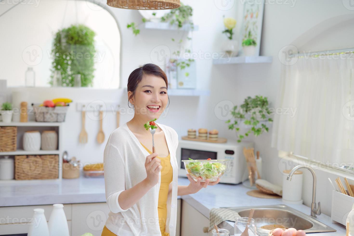 Portrait of a girl looking positive and holding a bawl with salad photo