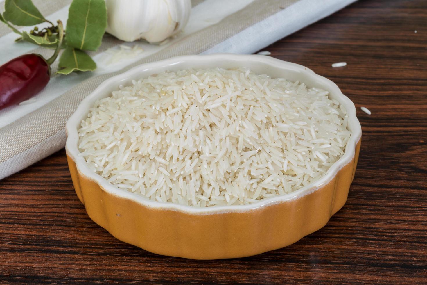 Basmati rice in a bowl on wooden background photo