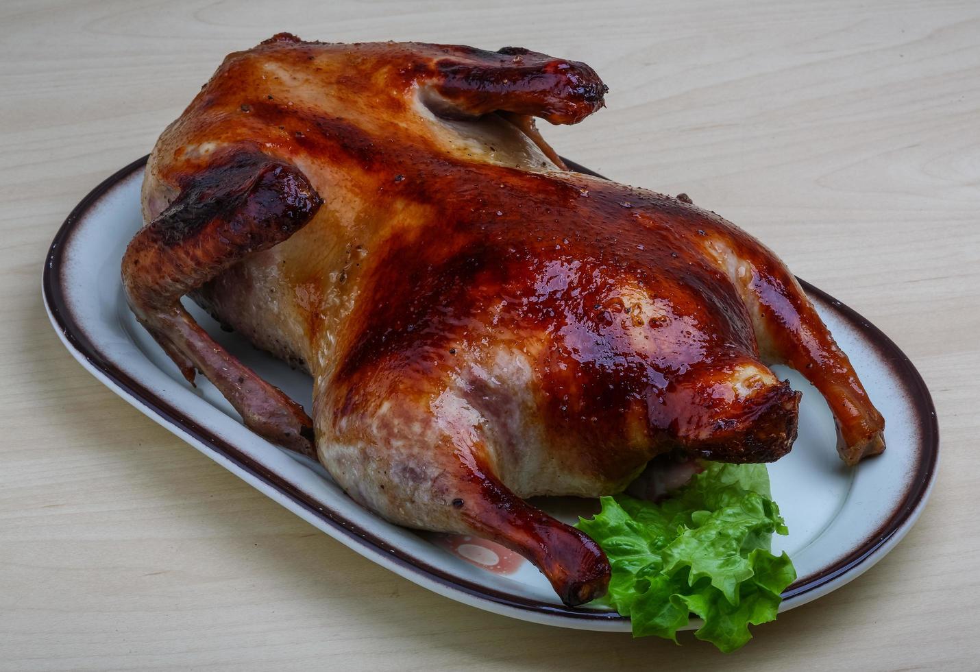 Roasted duck on the plate and wooden background photo