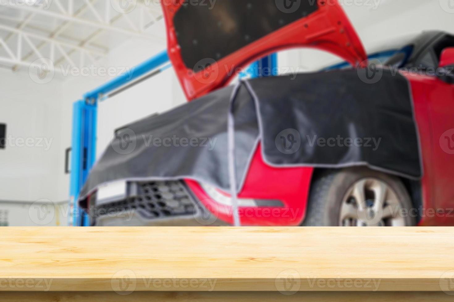 Empty wood table top with car service centre auto repair workshop blurred background photo