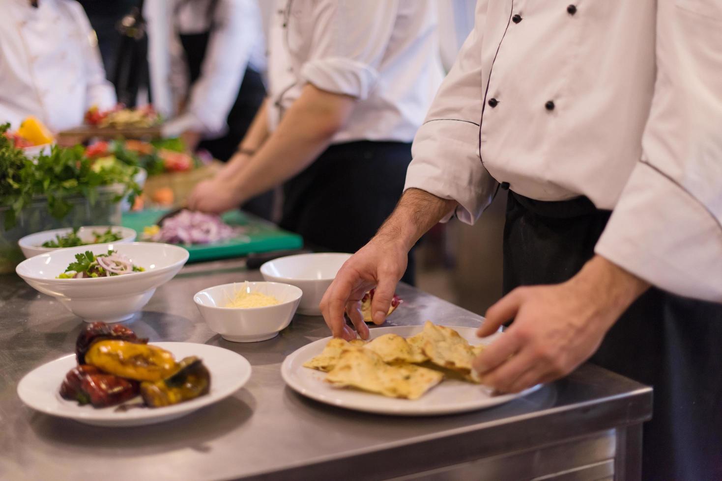 equipo de cocineros y chefs preparando comida foto