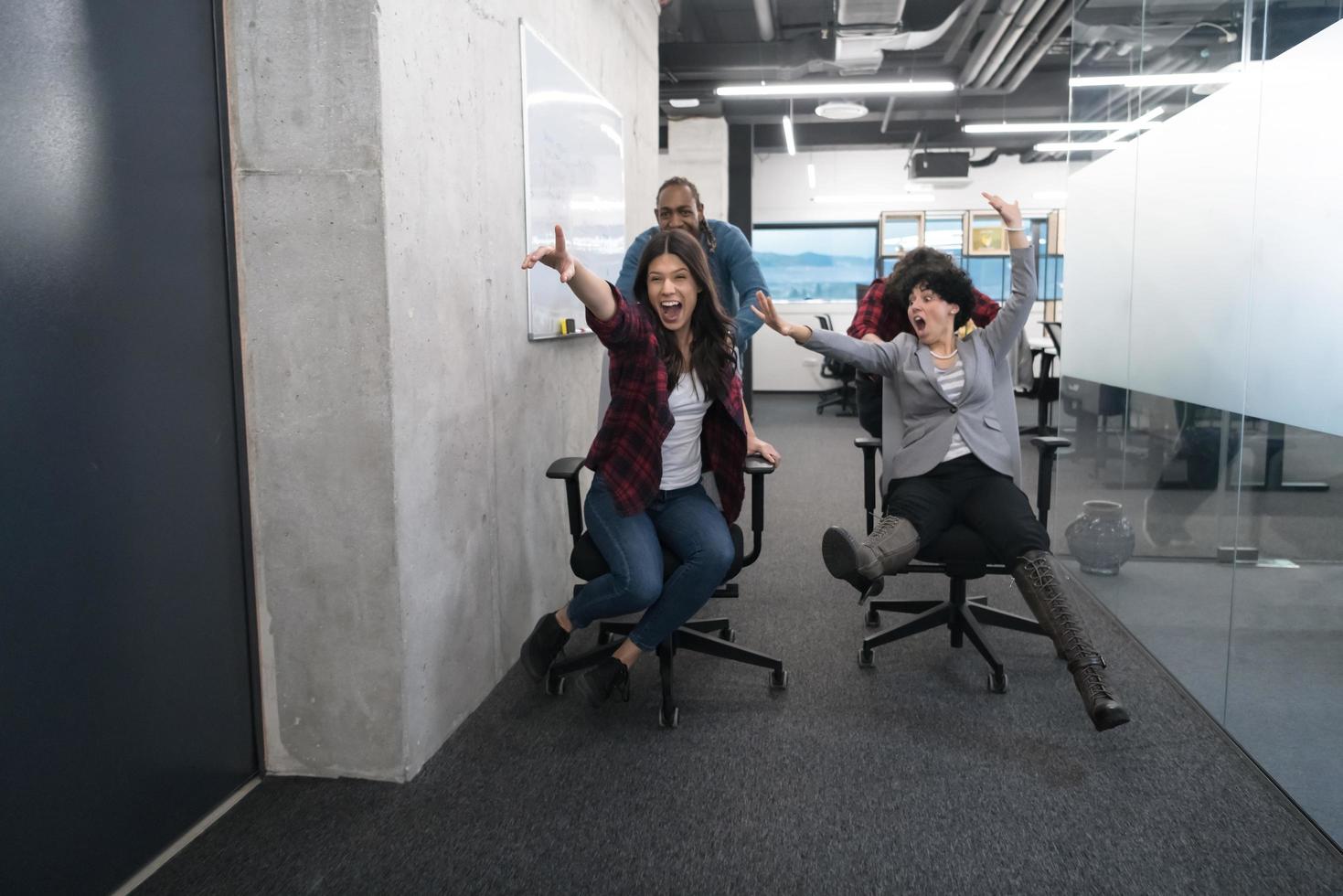 equipo de negocios multiétnico corriendo en sillas de oficina foto