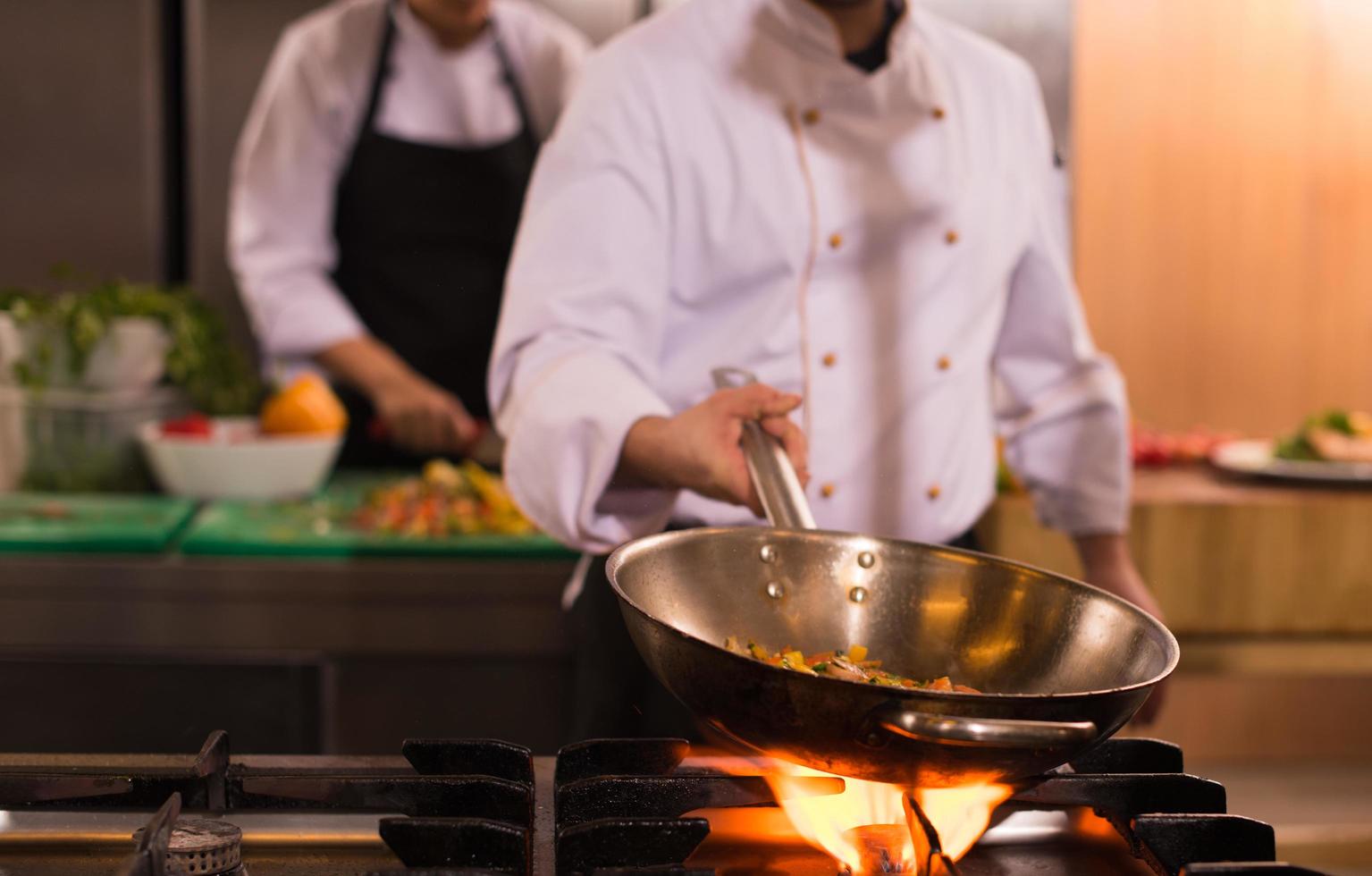 chef flipping vegetables in wok photo