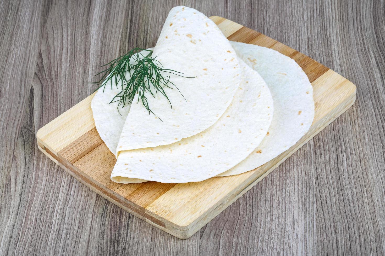 tortillas en tablero de madera y fondo de madera foto