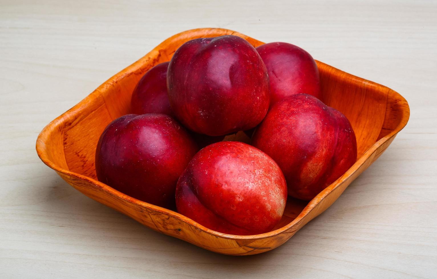 Nectarines in a bowl on wooden background 12728143 Stock Photo at Vecteezy