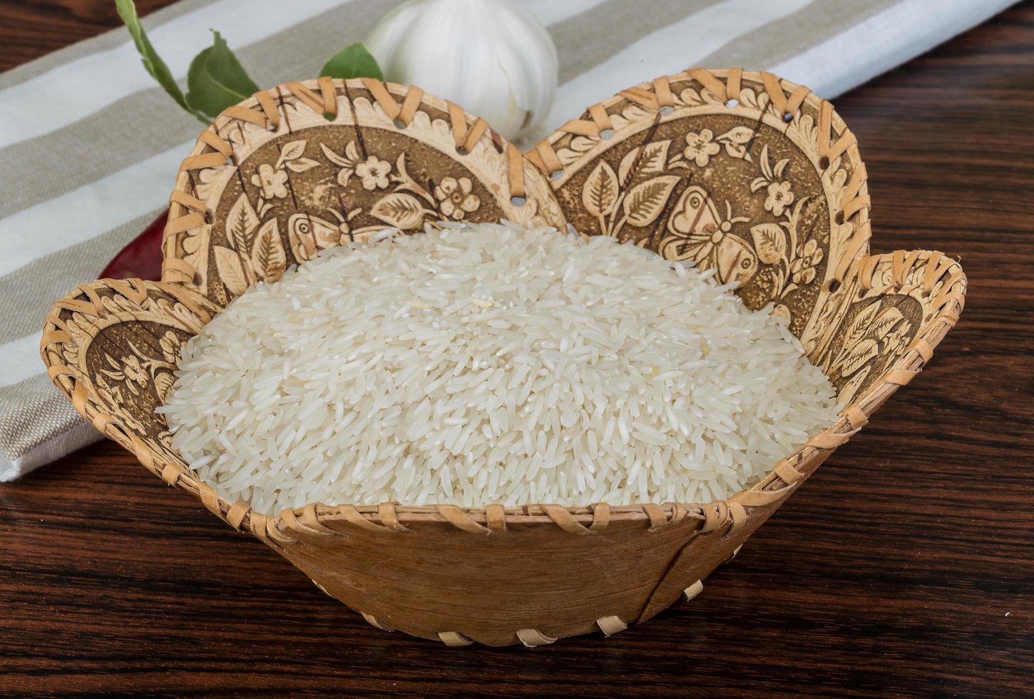 Basmati rice in a basket on wooden background photo