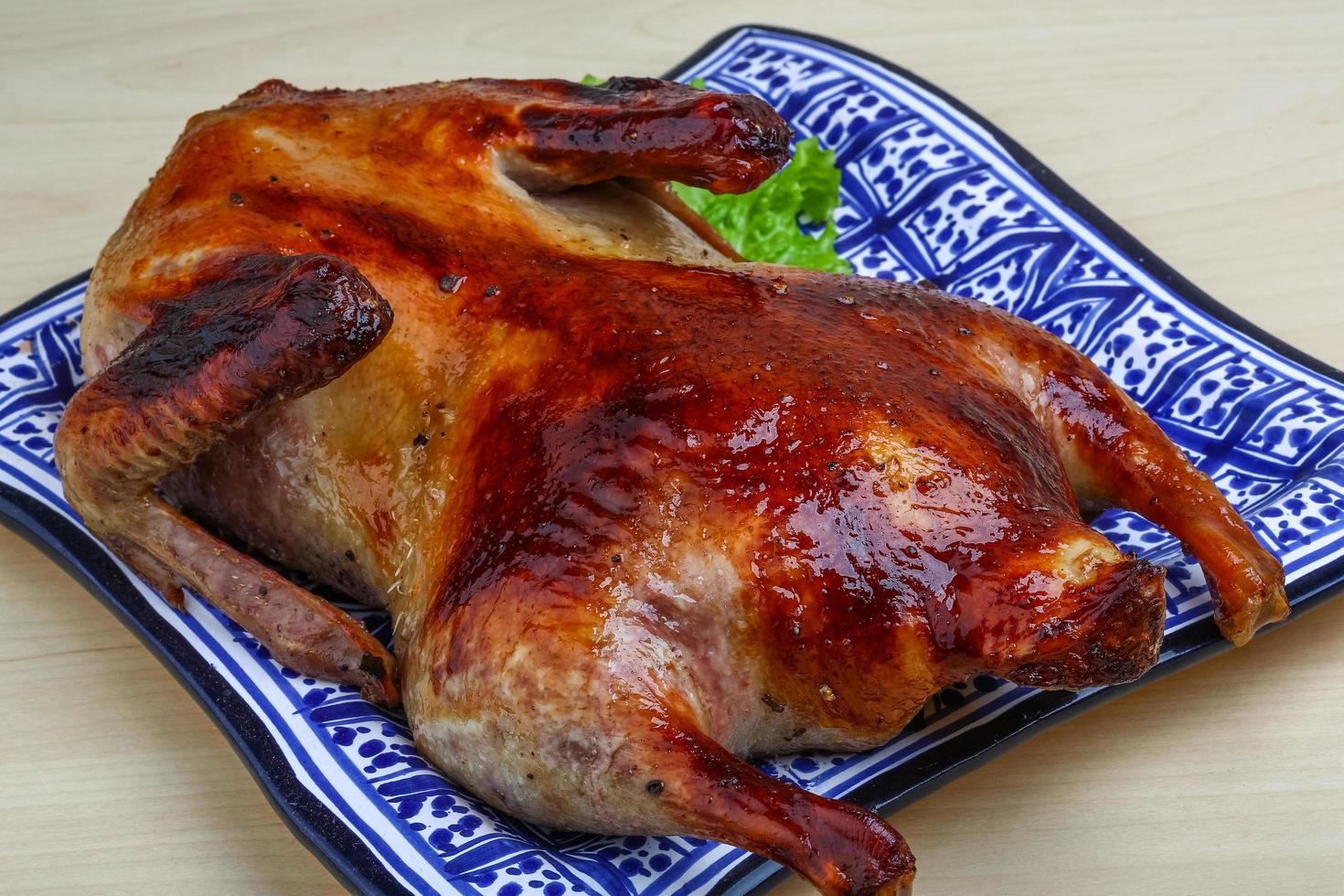 pato asado en el plato y fondo de madera foto