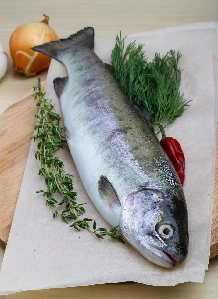 Raw trout on wooden board and wooden background photo