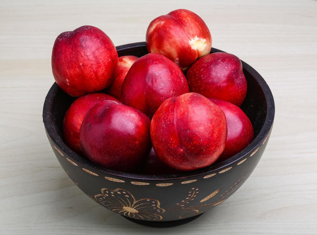 Nectarines in a bowl on wooden background 12728891 Stock Photo at Vecteezy