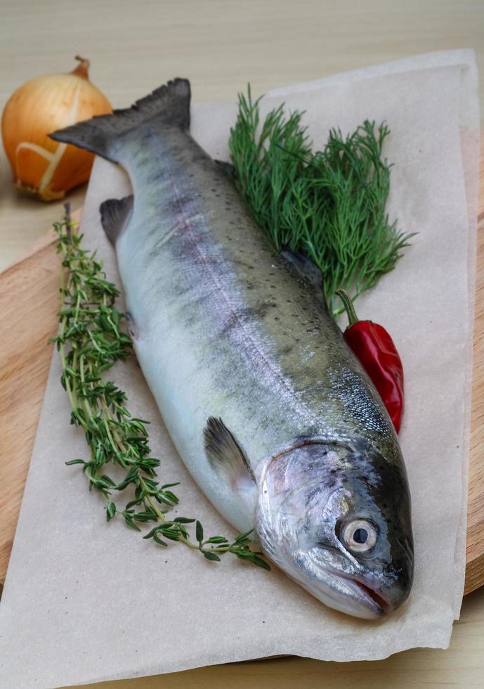 Raw trout on wooden board and wooden background photo