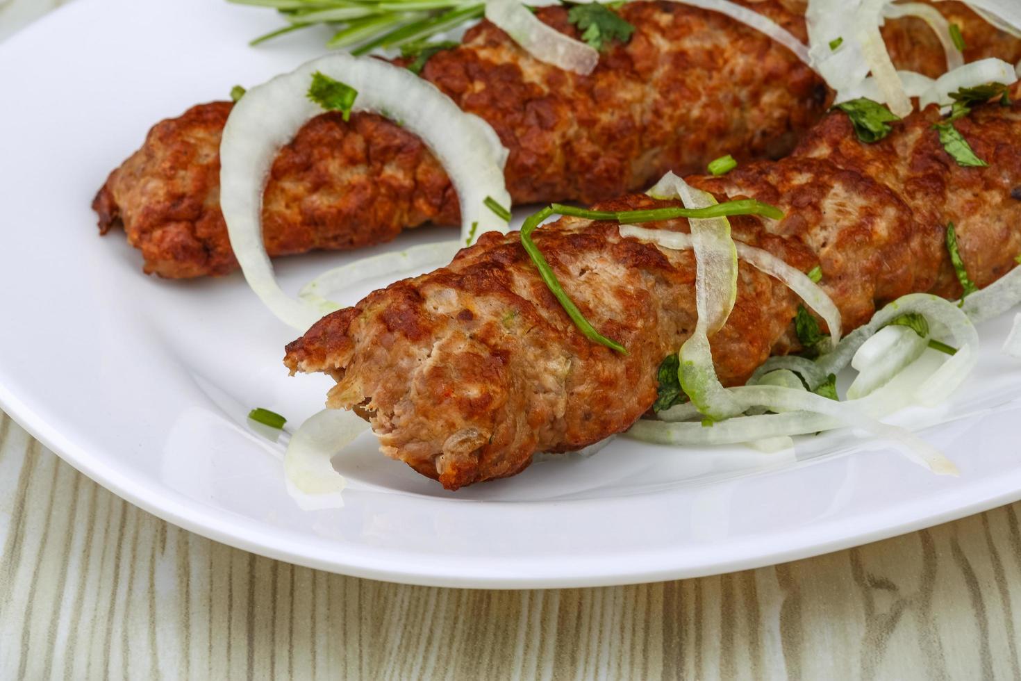 Beef kebab on the plate and wooden background photo
