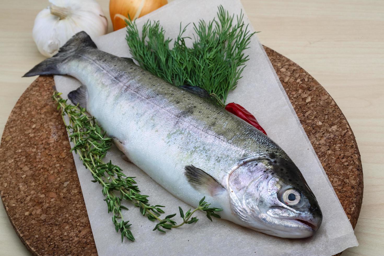 Raw trout on wooden board and wooden background photo