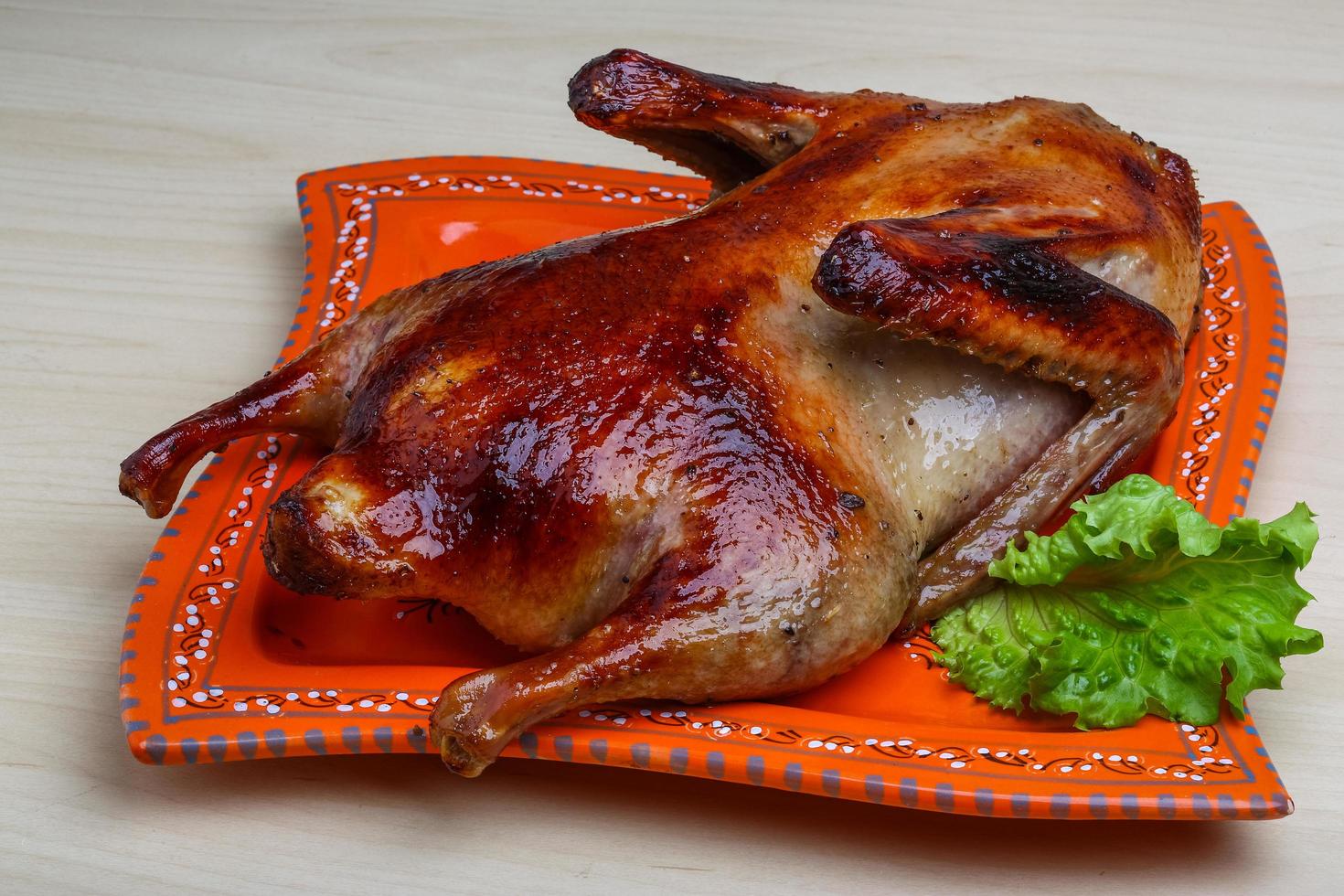 Roasted duck on the plate and wooden background photo