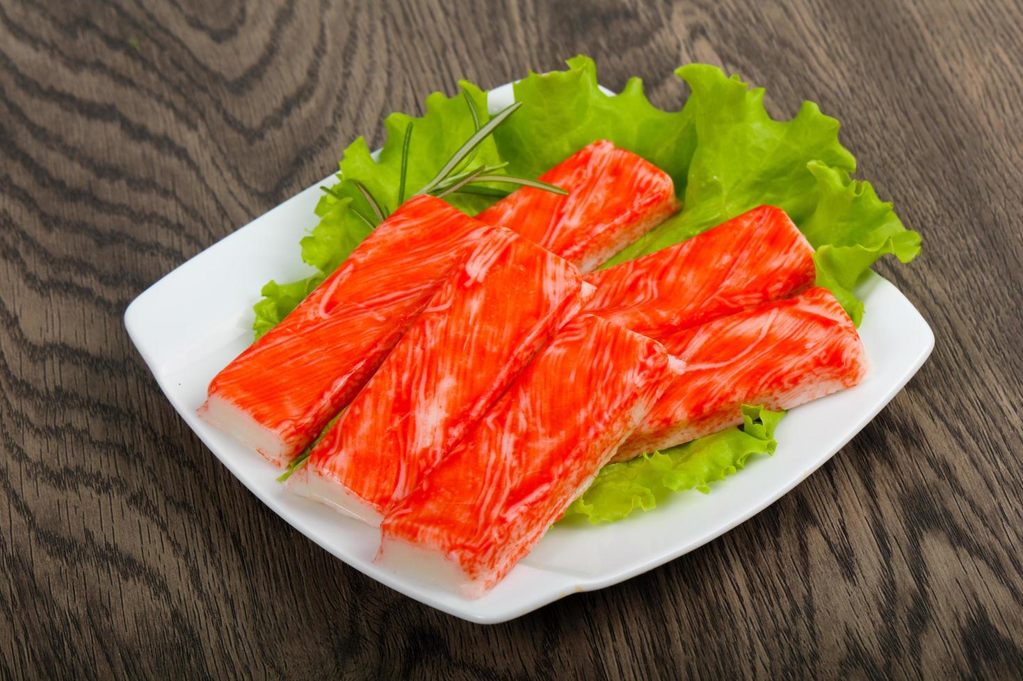 Crab sticks on the plate and wooden background photo