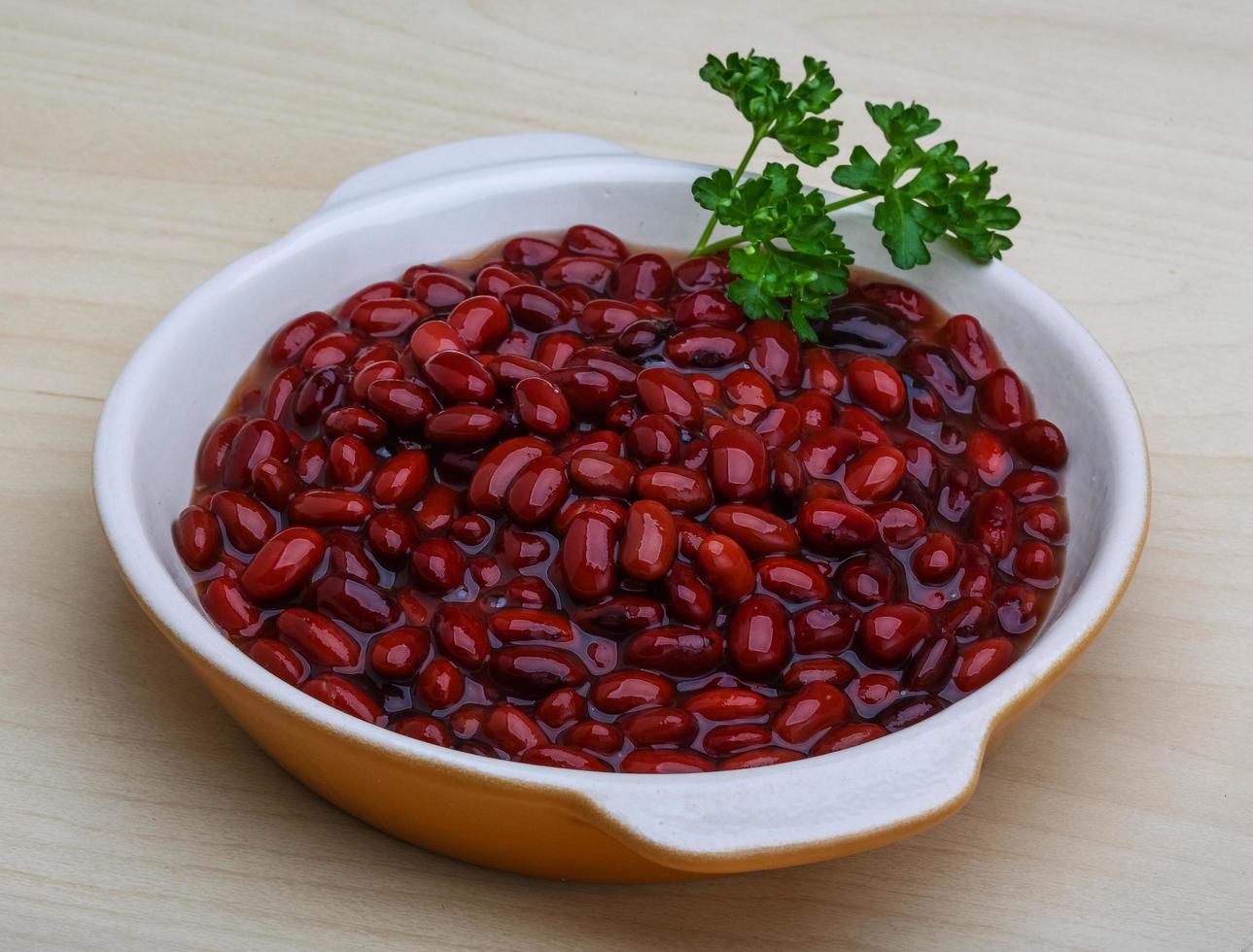 Canned beans in a bowl on wooden background photo