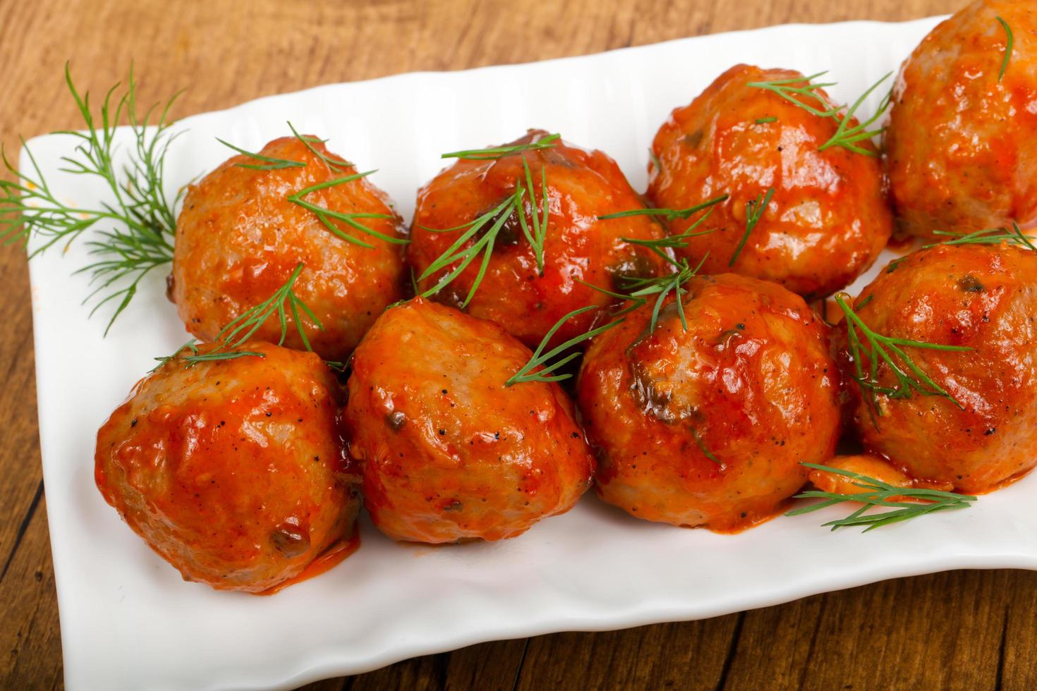 Meat balls on the plate and wooden background photo