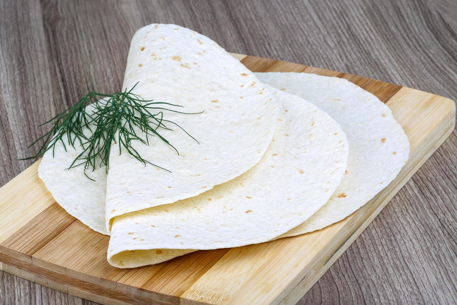 tortillas en tablero de madera y fondo de madera foto