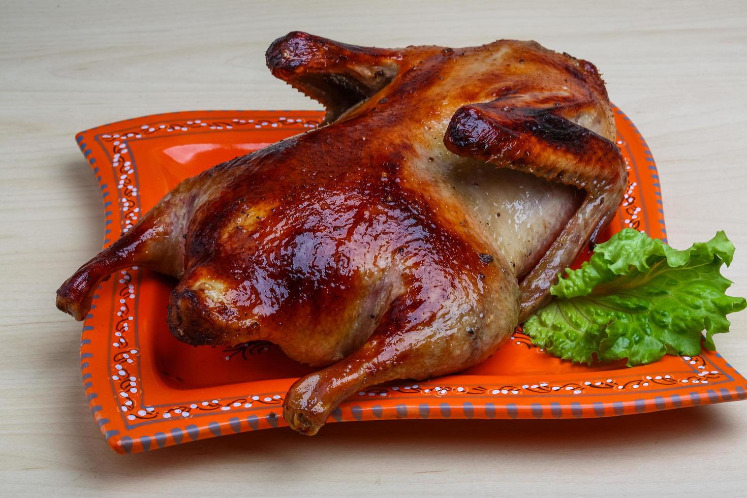 pato asado en el plato y fondo de madera foto