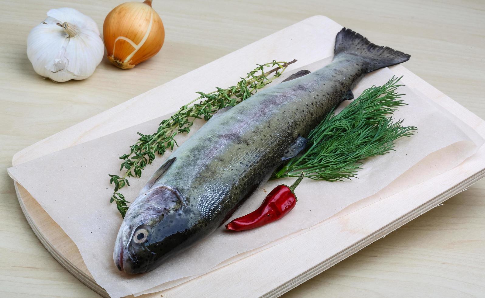 Raw trout on wooden board and wooden background photo