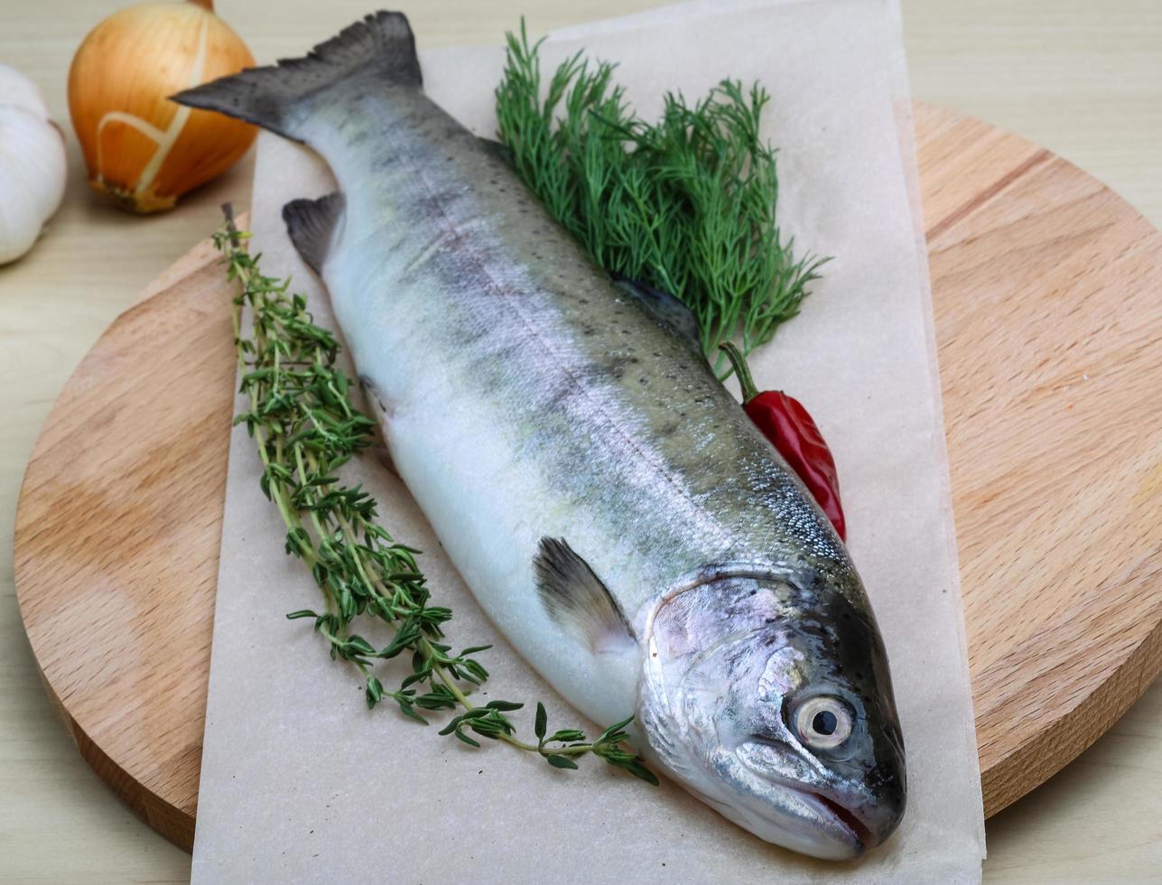 Raw trout on wooden board and wooden background photo