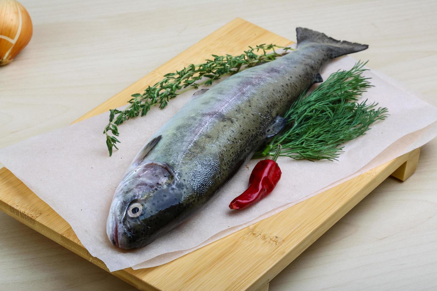 Raw trout on wooden board and wooden background photo