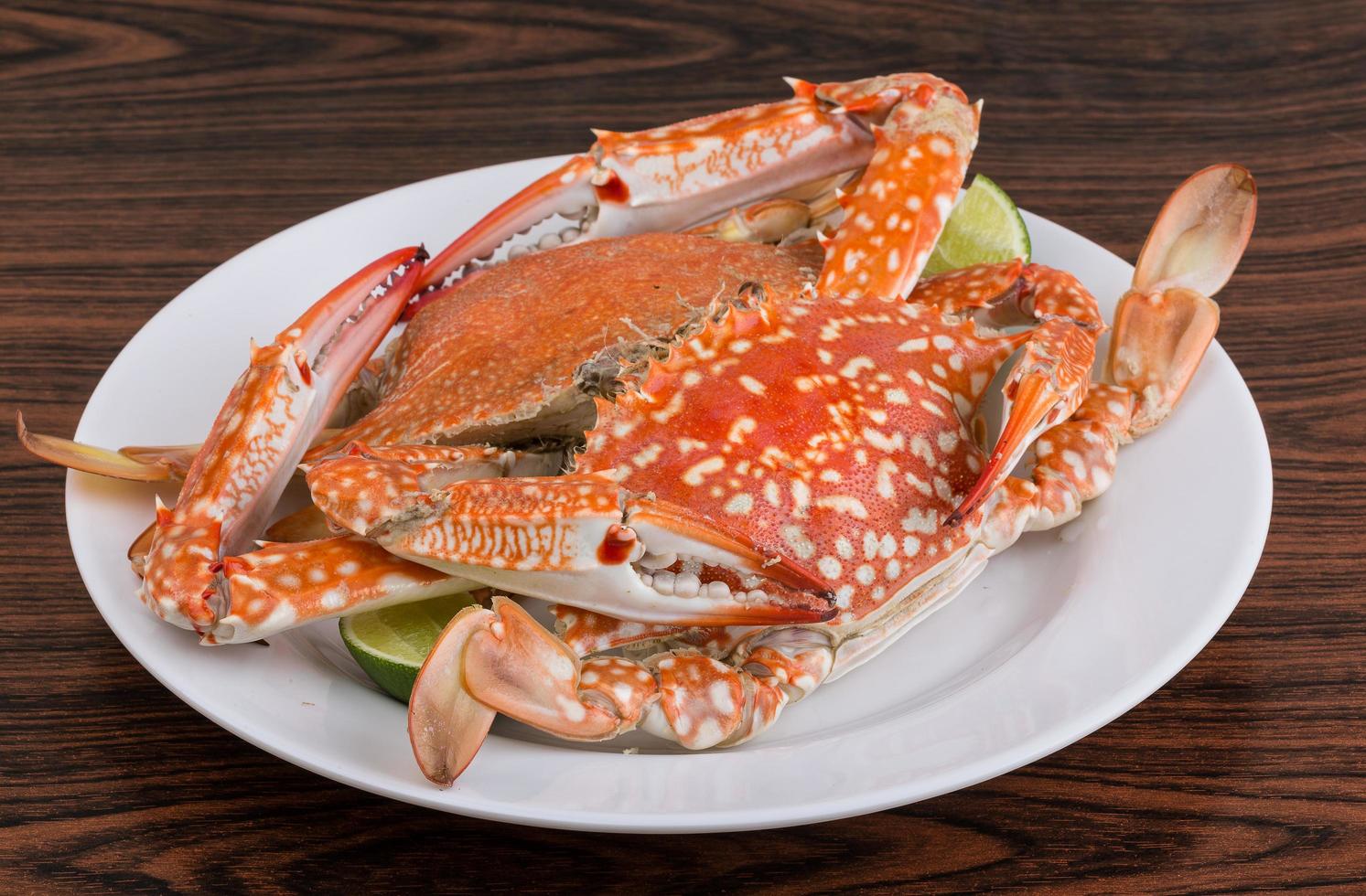 Boiled crabs on the plate and wooden background photo