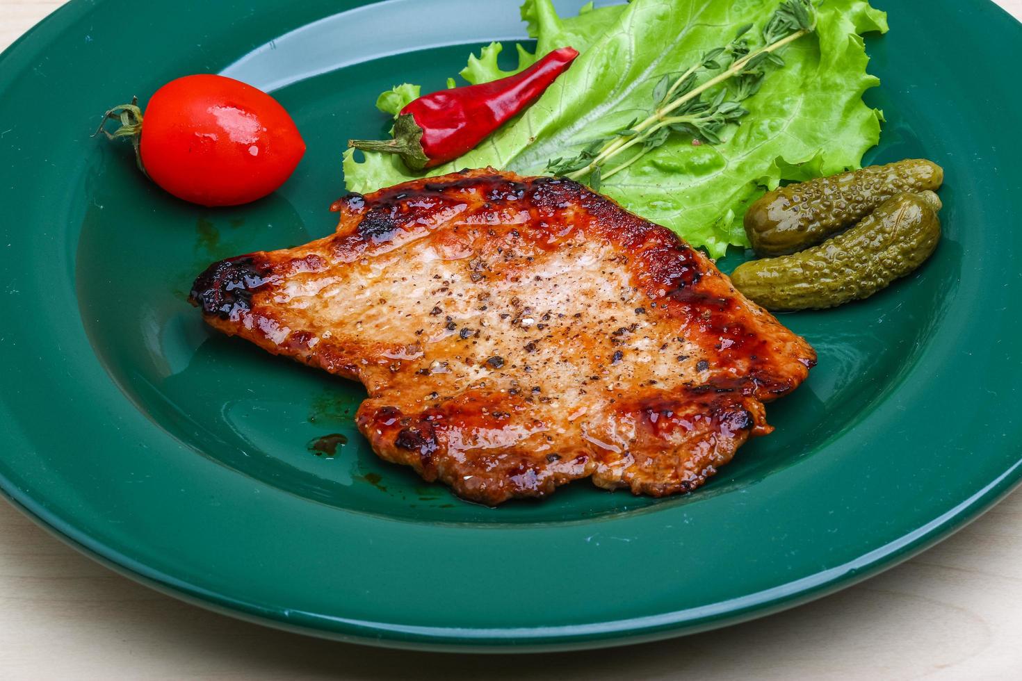 Roasted pork on the plate and wooden background photo