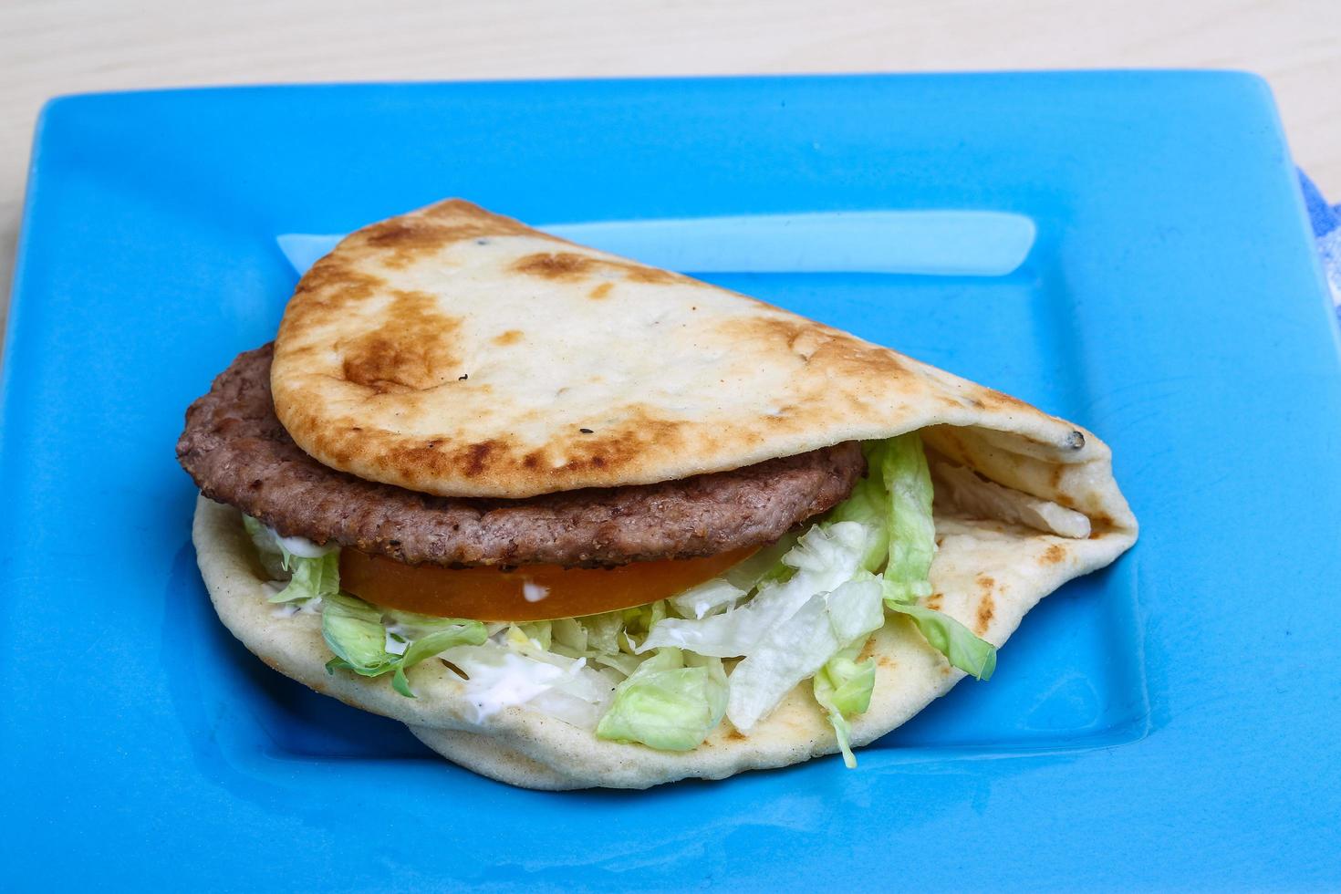 Greek pita on the plate and wooden background photo