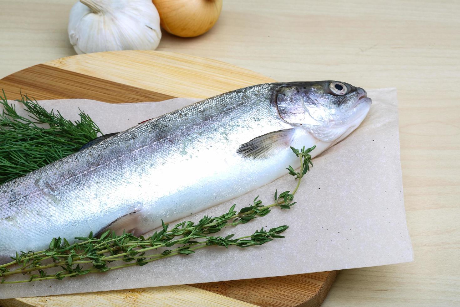 Raw trout on wooden board and wooden background photo