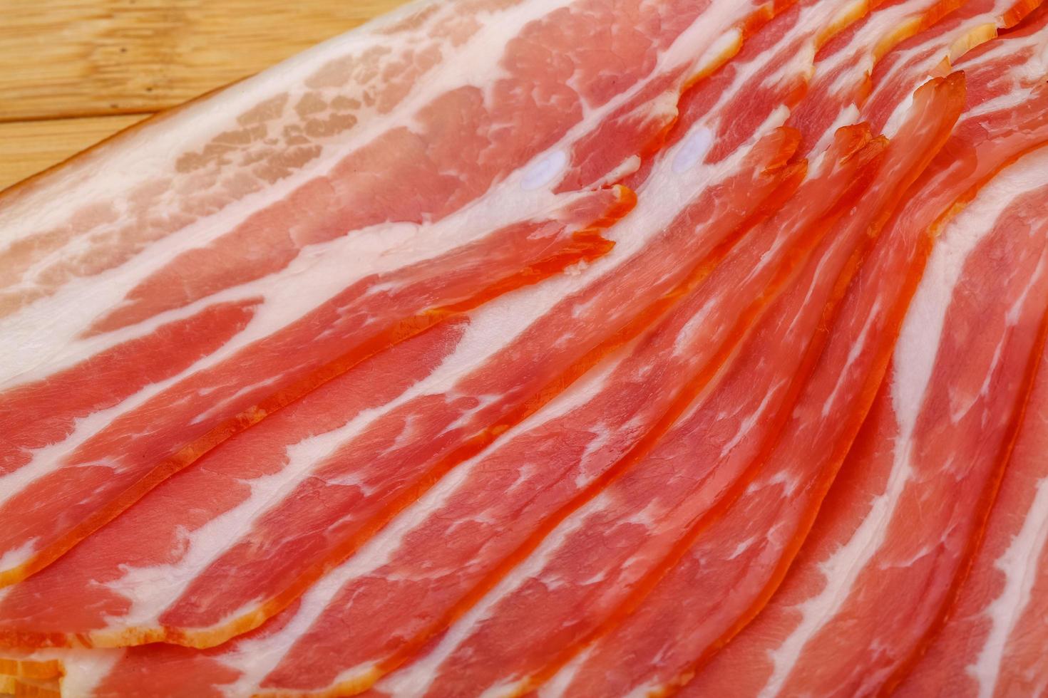 Sliced bacon on wood photo